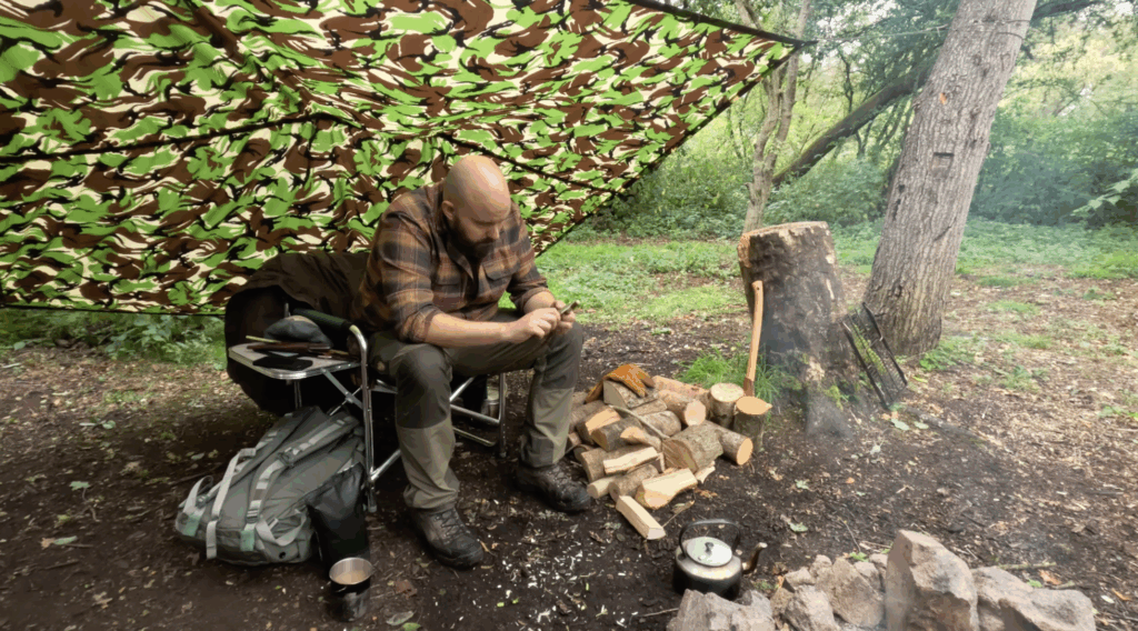 Author whittling a stick in the woods by the camp fire